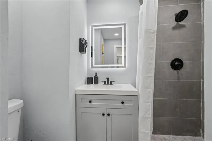 Full bath featuring a shower stall and vanity