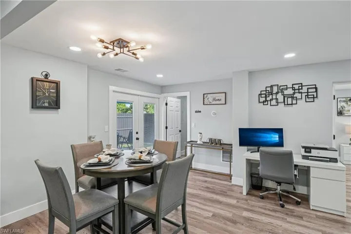 Dining space featuring french doors, light wood-type flooring, a chandelier, an office area, and recessed lighting