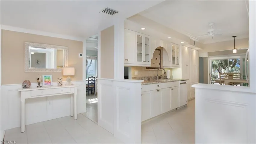 Kitchen featuring ornamental molding, ceiling fan, sink, dishwasher, and white cabinets