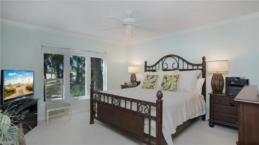 Bedroom featuring ceiling fan, crown molding, and light carpet