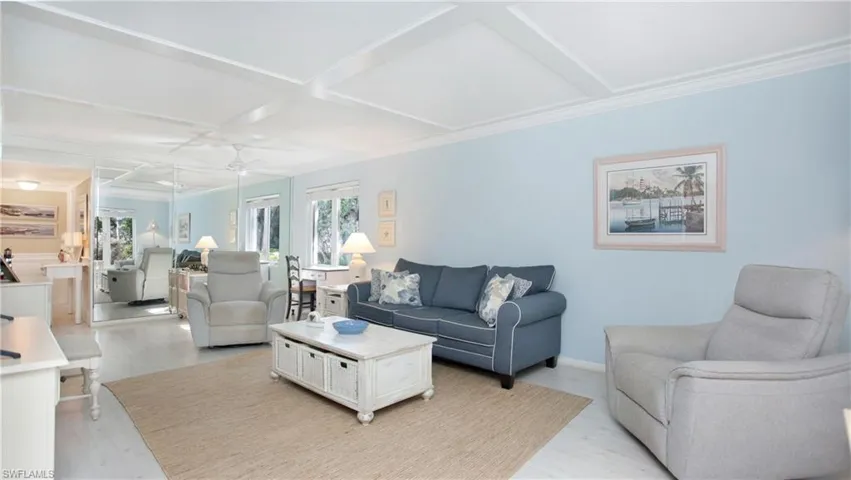 Living room with ceiling fan, crown molding, light hardwood / wood-style floors, and coffered ceiling
