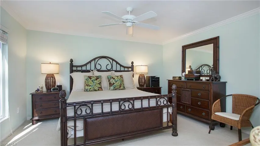 Bedroom featuring light colored carpet, ceiling fan, and ornamental molding