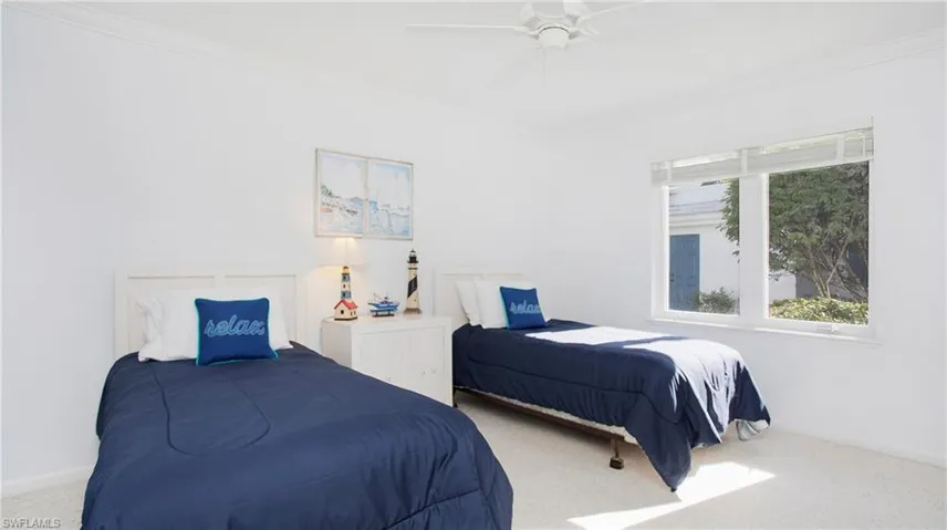 Carpeted bedroom with ceiling fan and ornamental molding