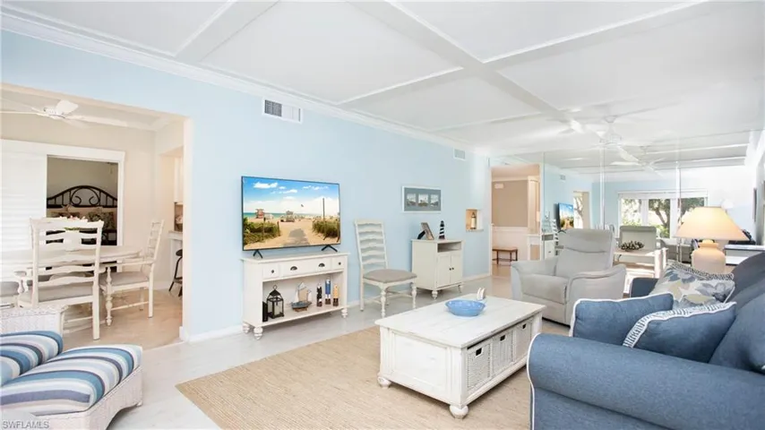 Living room featuring beam ceiling, ceiling fan, coffered ceiling, light hardwood / wood-style floors, and ornamental molding