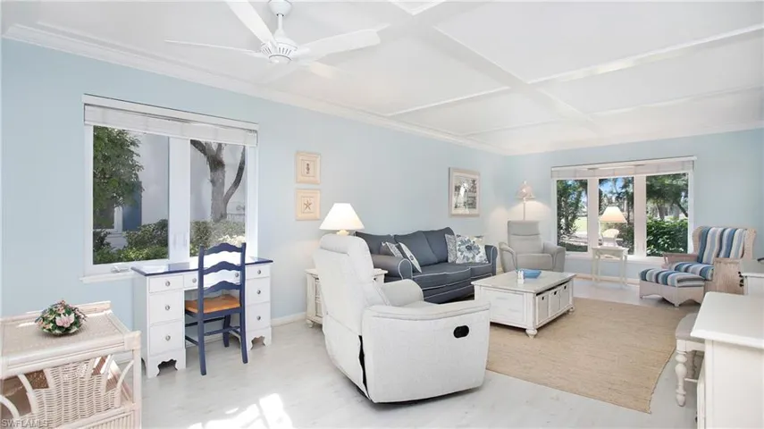 Living room featuring ceiling fan, light hardwood / wood-style flooring, coffered ceiling, and ornamental molding