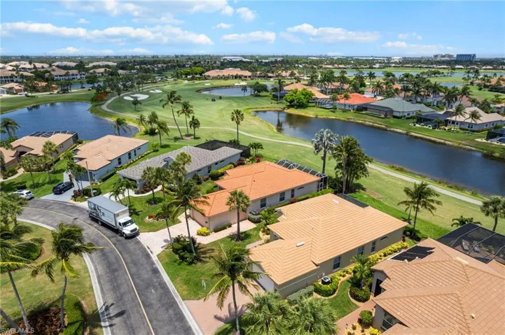 Aerial view of residential area with a nearby body of water and a golf course