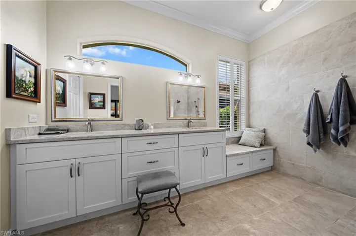 Full bathroom featuring crown molding and double vanity