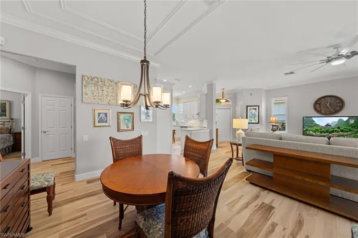 Dining space with light wood-type flooring, a ceiling fan, recessed lighting, a chandelier, and plenty of natural light