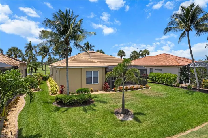 View of front of home with stucco siding, a front lawn, and a tile roof