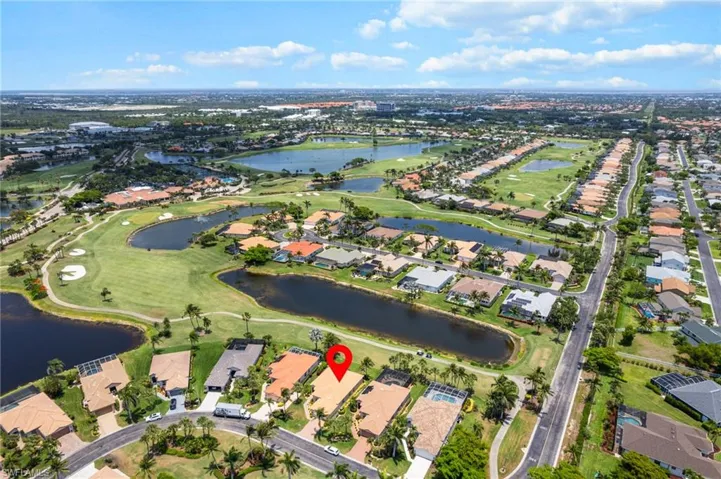 Aerial view of property's location featuring nearby suburban area, a nearby body of water, and a golf club