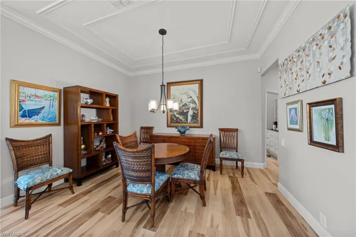 Dining space with light wood-type flooring, a chandelier, baseboards, and ornamental molding