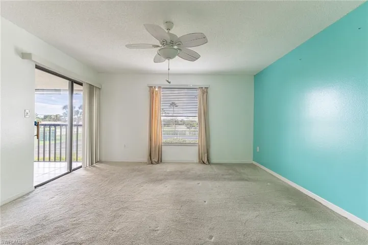 Carpeted spare room with healthy amount of natural light, a textured ceiling, and a ceiling fan