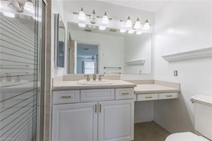 Full bath featuring vanity, a stall shower, and light tile patterned floors
