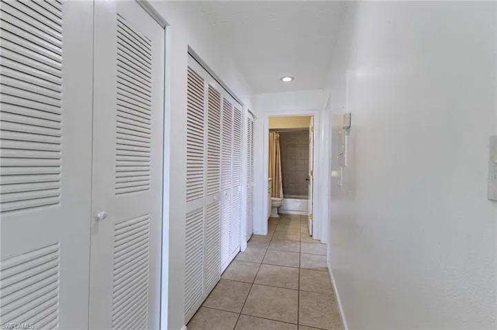 Hall featuring light tile patterned floors and a textured ceiling