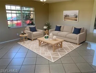 Living room featuring light tile patterned floors and baseboards