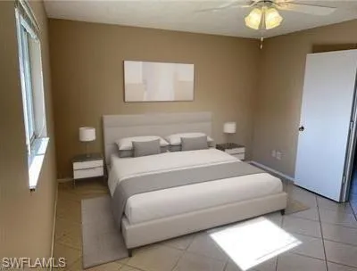 Tiled bedroom featuring ceiling fan and baseboards