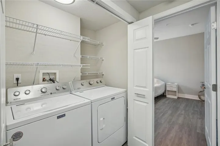Clothes washing area featuring washer and clothes dryer, hardwood / wood-style floors, and hookup for a washing machine