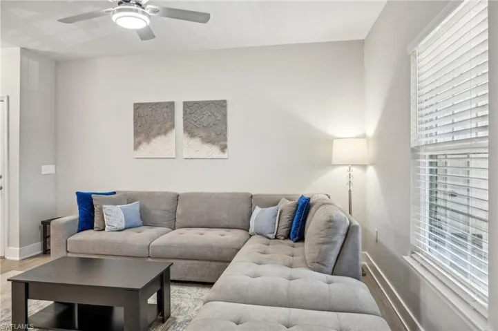 Living room with ceiling fan and hardwood / wood-style floors
