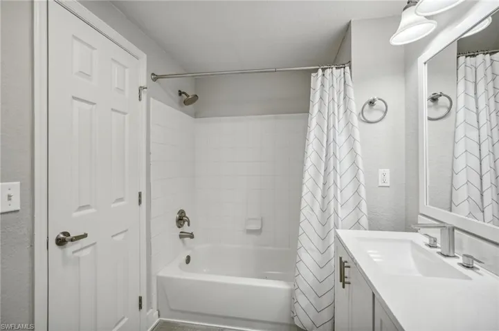 Bathroom featuring shower / bath combo with shower curtain and vanity