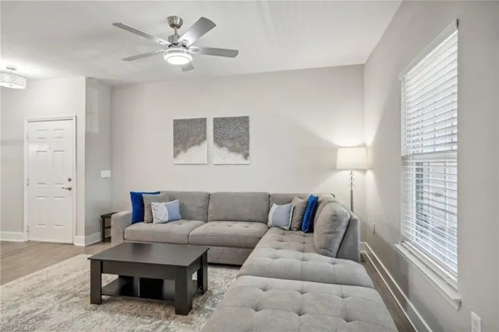 Living room with ceiling fan and hardwood / wood-style flooring
