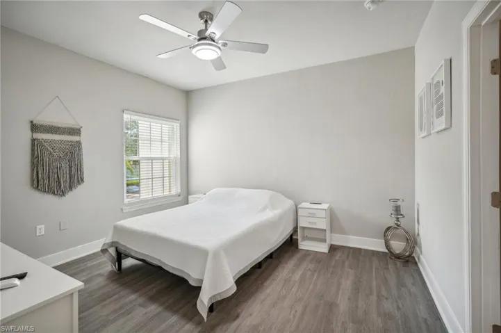 Bedroom with ceiling fan and dark wood-type flooring