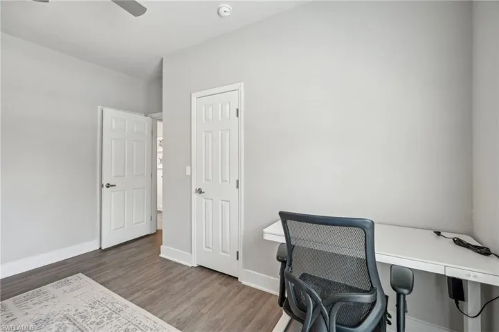 Office with ceiling fan and hardwood / wood-style flooring