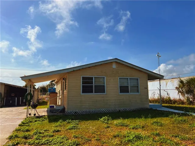 View of property exterior featuring a yard and a carport