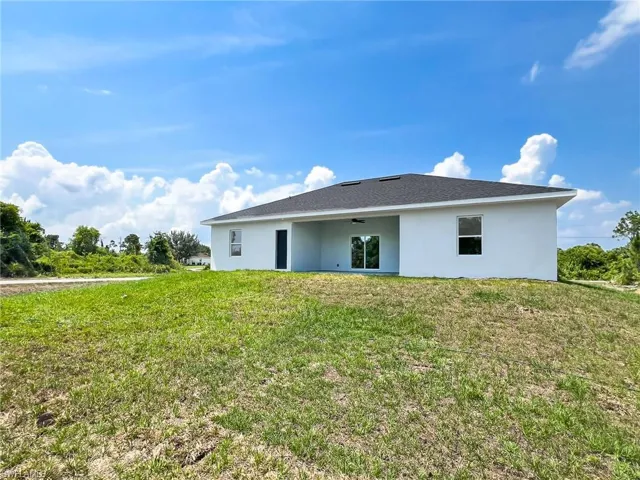 Back of property featuring a lawn