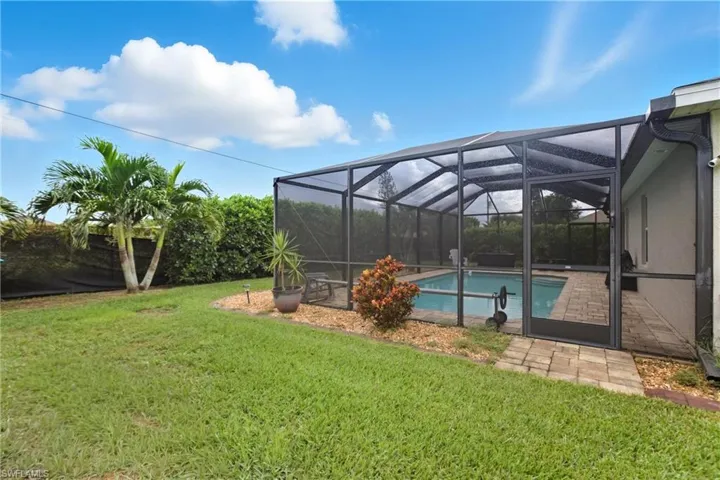 Swimming pool with  screen enclosure, a yard, a patio, and a sunroom