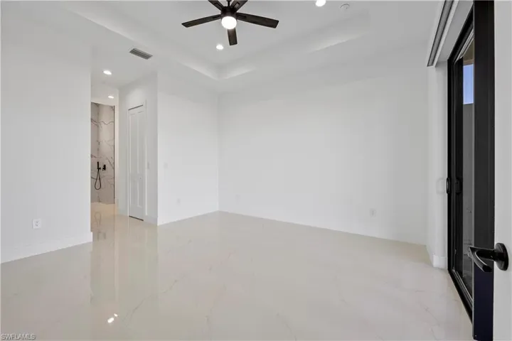 Unfurnished room featuring visible vents, a raised ceiling, marble finish floor, recessed lighting, and baseboards
