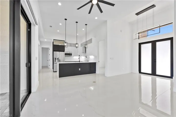 Kitchen with marble finish floor, modern cabinets, stainless steel appliances, french doors, and light countertops