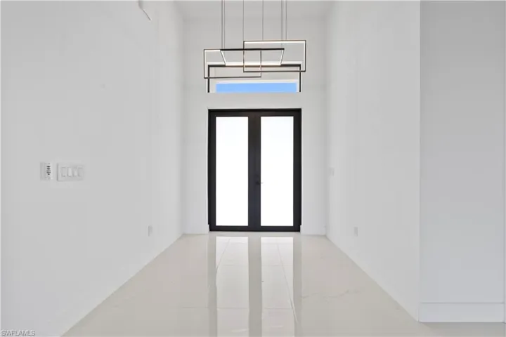Spare room featuring marble finish floor, french doors, and baseboards