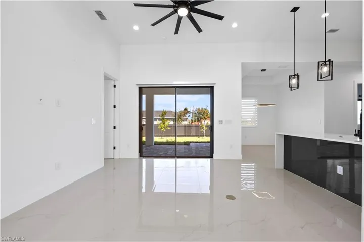Unfurnished living room with a ceiling fan, recessed lighting, visible vents, and marble finish floor