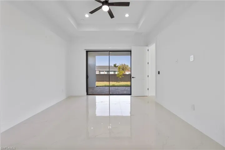 Unfurnished room featuring visible vents, marble finish floor, a tray ceiling, recessed lighting, and baseboards
