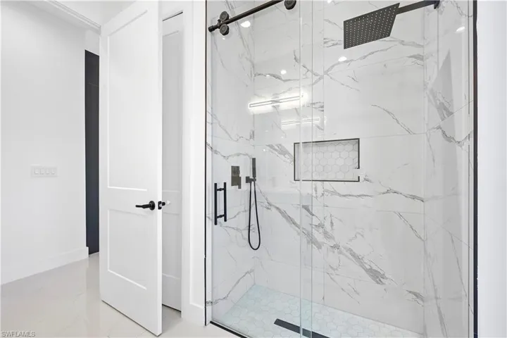 Bathroom with a marble finish shower, marble finish floor, and baseboards