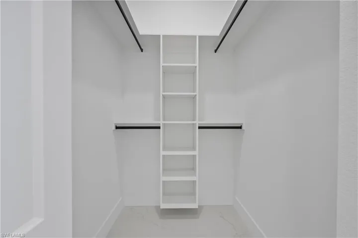 Walk in closet with marble finish floor