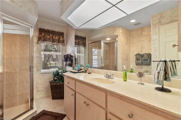 Bathroom with wallpapered walls, vanity, a shower stall, tile patterned floors, and recessed lighting