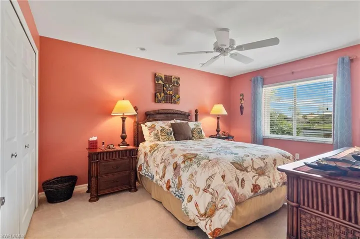 Bedroom featuring light colored carpet, a closet, and a ceiling fan