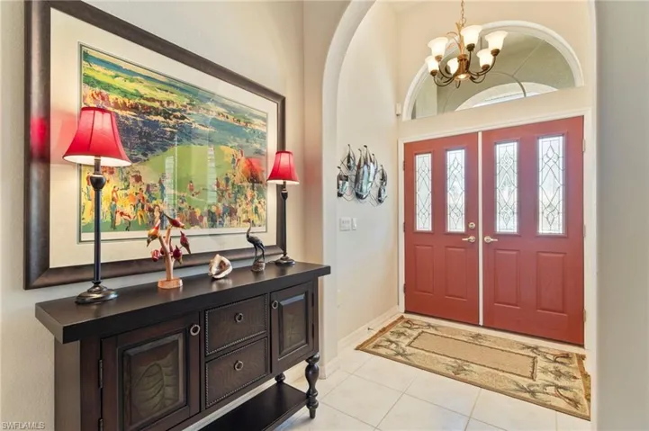 Foyer entrance with a chandelier and light tile patterned flooring