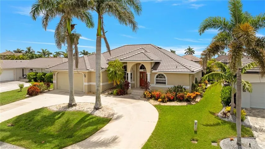 View of front facade featuring concrete driveway, a front lawn, an attached garage, stucco siding, and a tiled roof