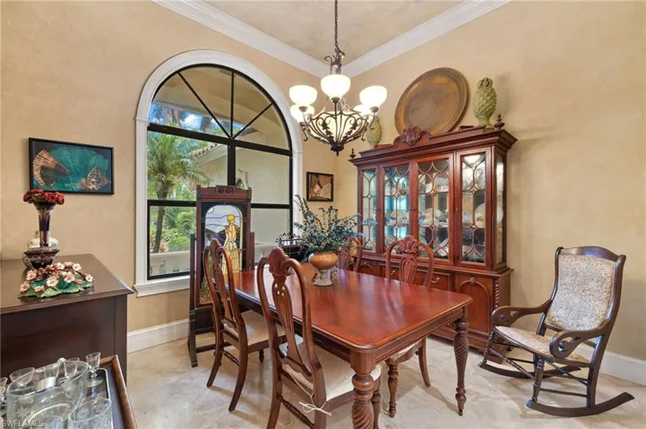 Dining area with ornamental molding, fauxe and an inviting chandelier