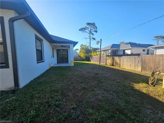 Fenced backyard featuring a ceiling fan and a patio area