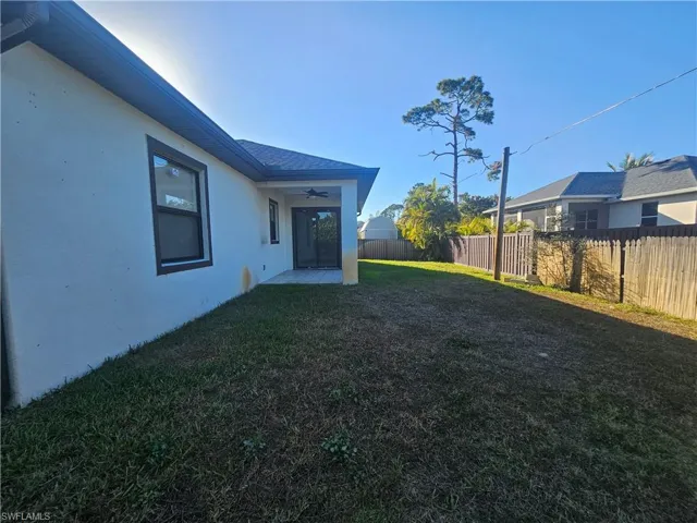 Fenced backyard with ceiling fan and a patio area