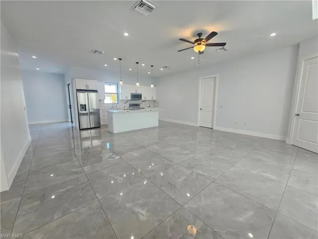 Unfurnished living room featuring ceiling fan, recessed lighting, and light marble finish flooring