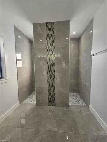 Bathroom with walk in shower and marble tiled flooring