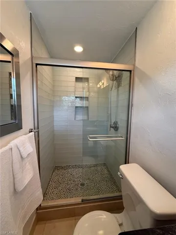 Full Bathroom featuring a glasstile shower stall with frameless glass slider