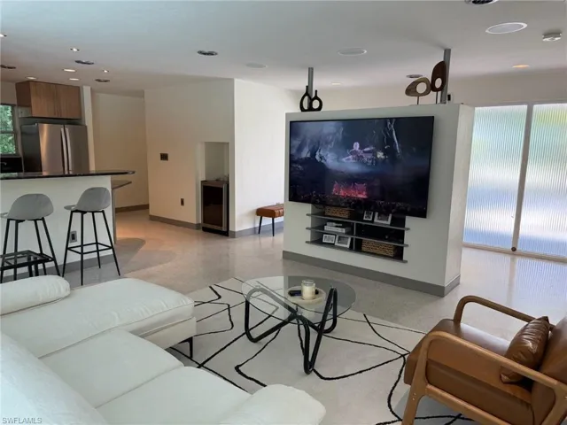 Living area featuring plenty of natural light, extr beverage cooler, and built-in TV wall with dolby surround sound and 75" Sony TV