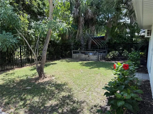 Fenced backyard featuring a vegetable garden