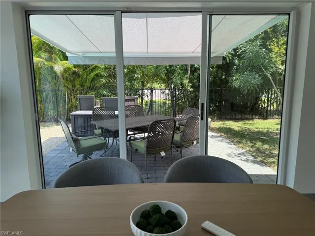 View from the Dining room to the outdoor patio dining area under a motorzed awning