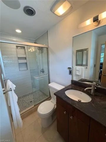 Full Bathroom with vanity, a shower stall, and sandstone floors